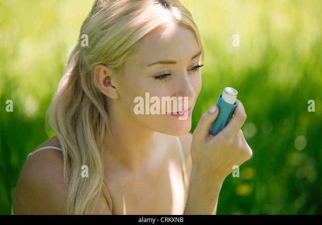 a-young-blond-woman-sitting-in-the-grass
