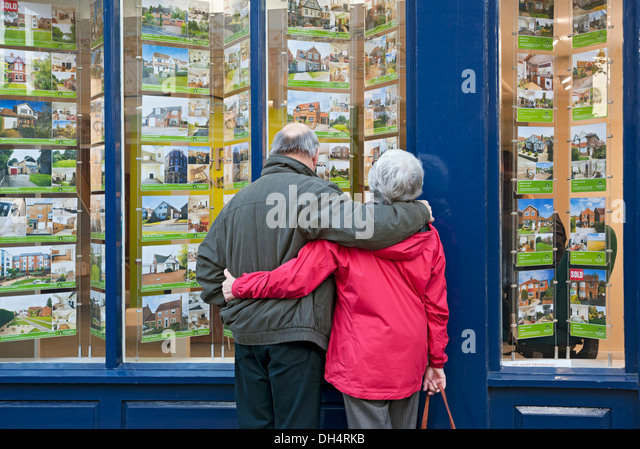 older-couple-looking-in-estate-agents-wi